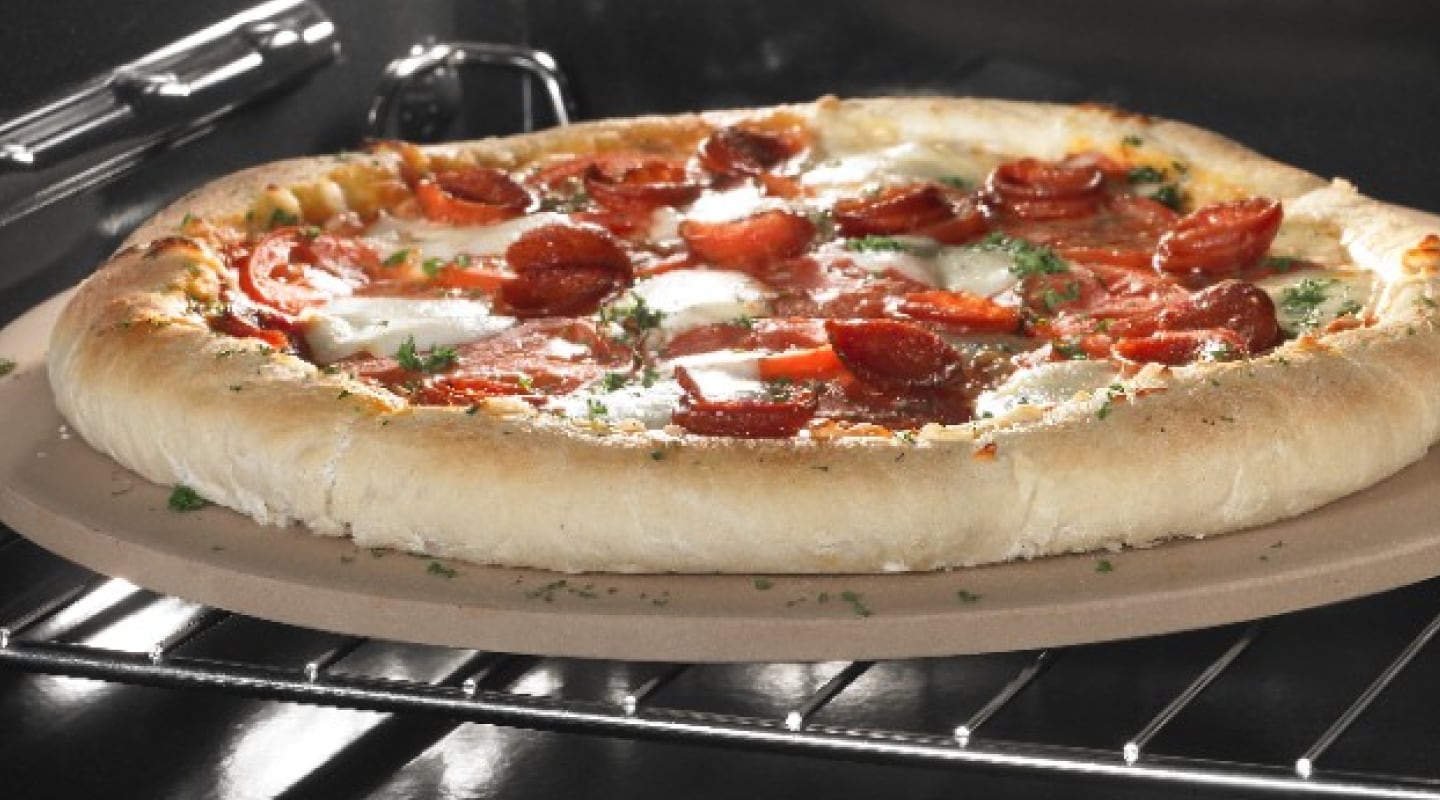 A pepperoni pizza baking in an oven. A pepperoni pizza baking in an oven.
