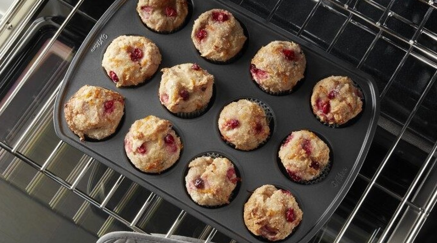 Overhead view of berry muffins baking on an oven rack. Overhead view of berry muffins baking on an oven rack.