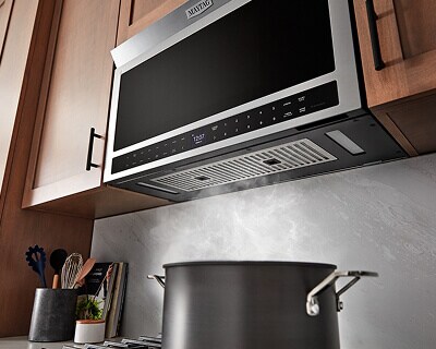 Water boiling in pot as over-the-range microwave vents air above