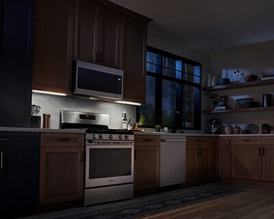 Maytag® over-the-range microwave casting light on stovetop below