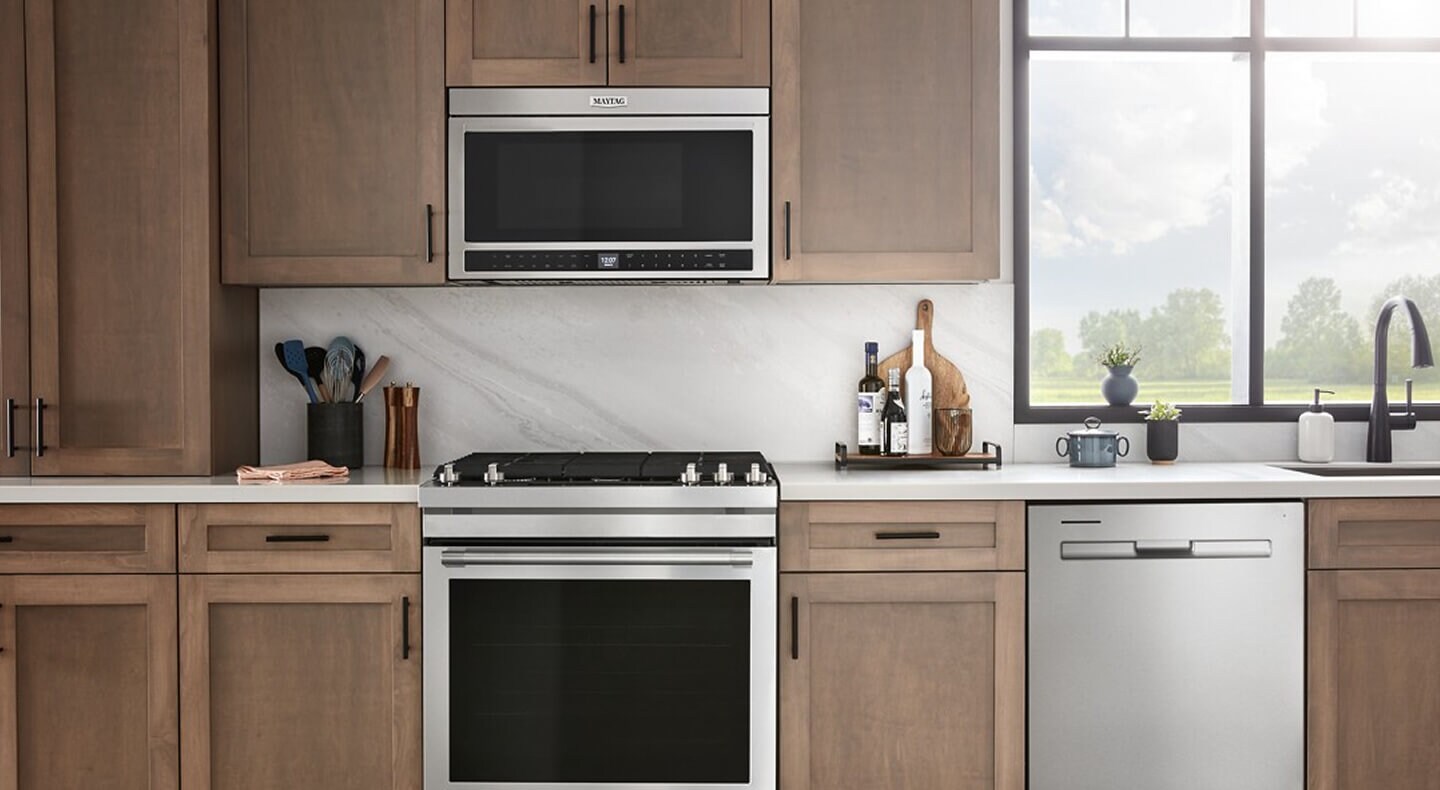 Stainless steel Maytag® over-the-range microwave in brown cabinetry