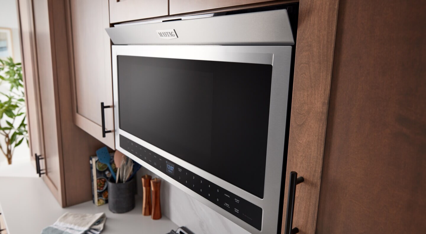 A flush Maytag® over-the-range microwave with the hidden vent opened