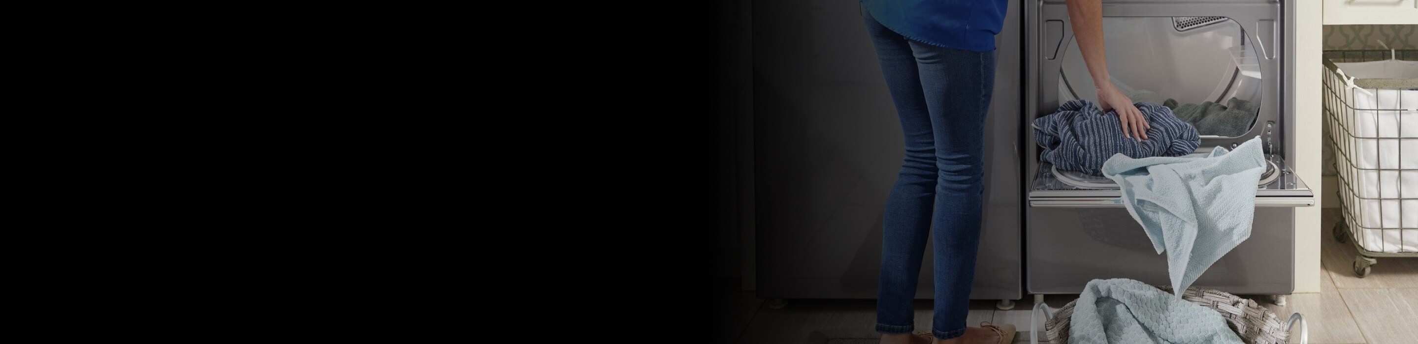 Woman loading clothes into a dryer