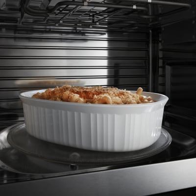Image of white dish with food in it on microwave turntable