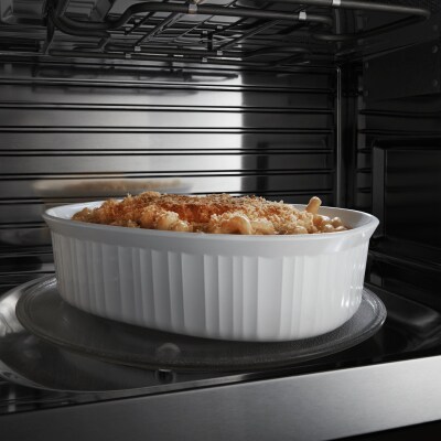 Image of white dish with food in it on microwave turntable