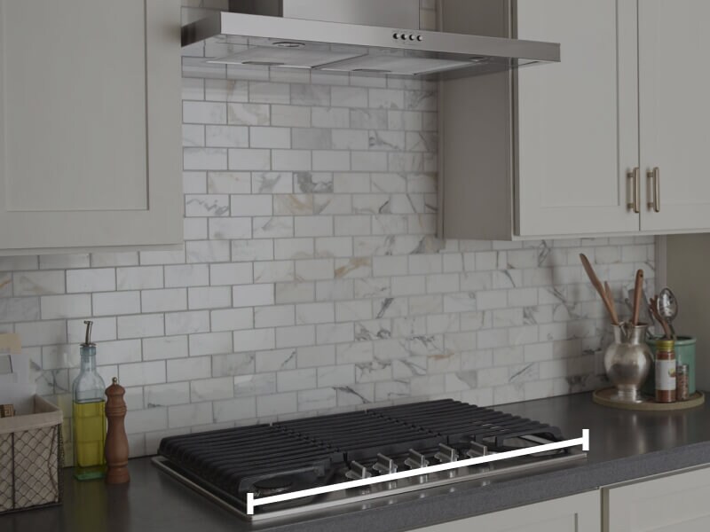 Range hood over cooktop with marks showing how to measure horizontally