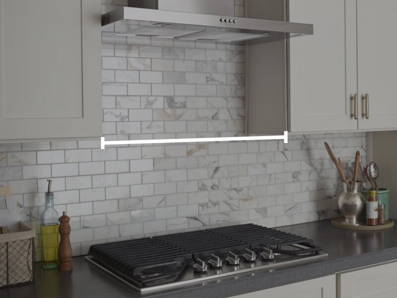 Range hood over cooktop with marks showing how to measure horizontally