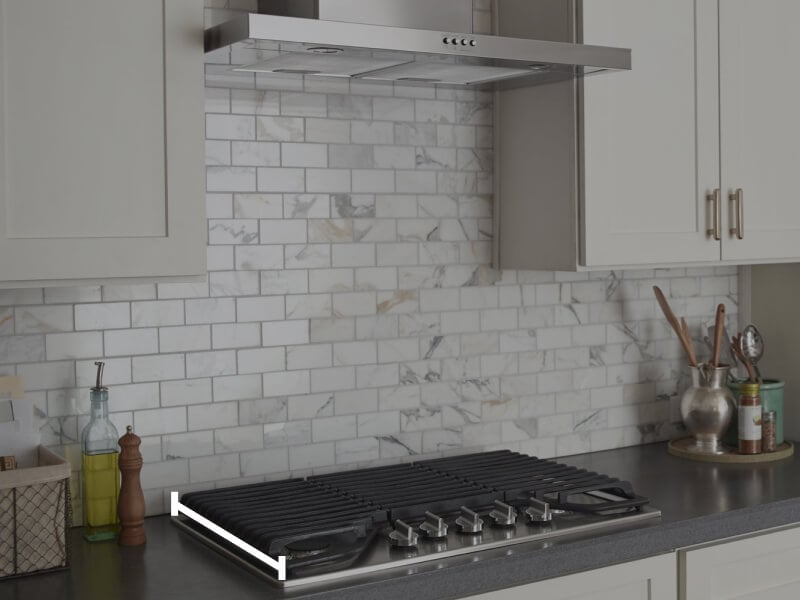 Range hood over cooktop with marks showing how to measure the cooktop