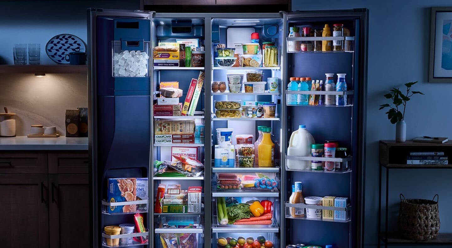 Arctic Blue Interior of a stocked Maytag® side-by-side refrigerator with open doors