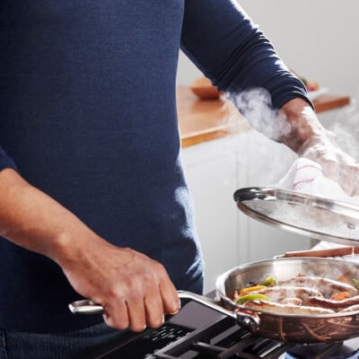 A person sauteing at a stove