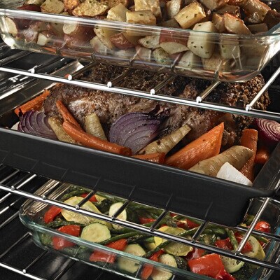 Meat and veggies in a pan on an oven rack