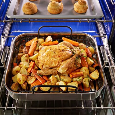 Meat and veggies in a pan on an oven rack