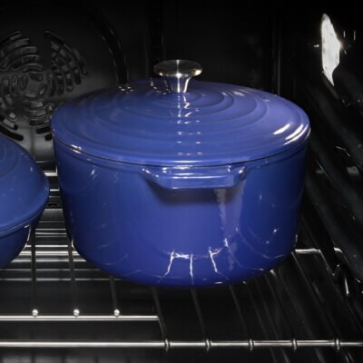 a blue dutch oven with a lid inside an oven
