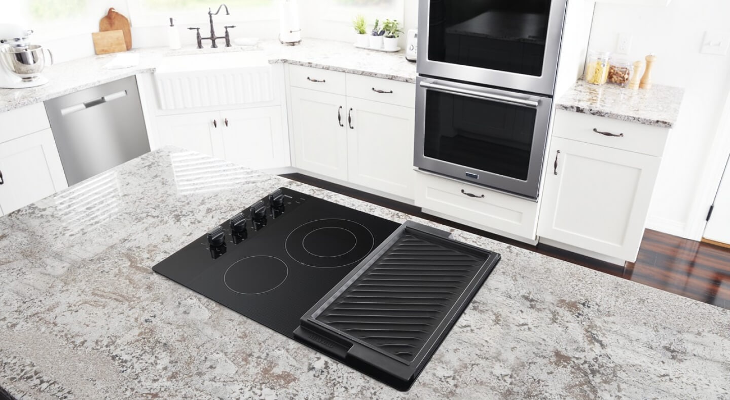 Electric cooktop with a griddle in a marble kitchen island