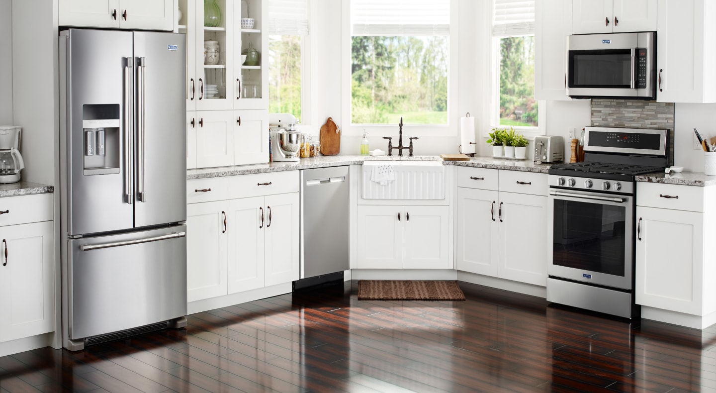 Various stainless steel appliances in a modern kitchen with white cabinetry  Various stainless steel appliances in a modern kitchen with white cabinetry