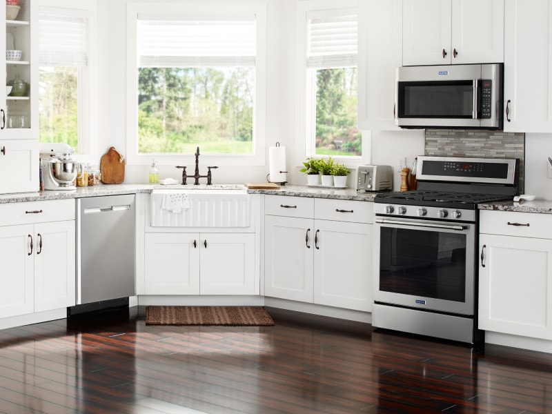 Various stainless steel appliances in a modern kitchen with white cabinetry  Various stainless steel appliances in a modern kitchen with white cabinetry