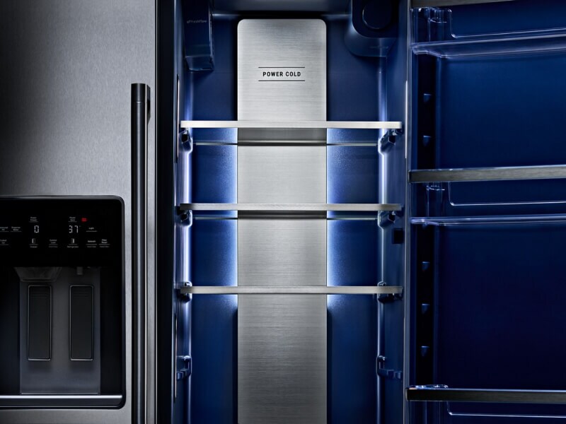 One side of a refrigerator open to show shelving inside