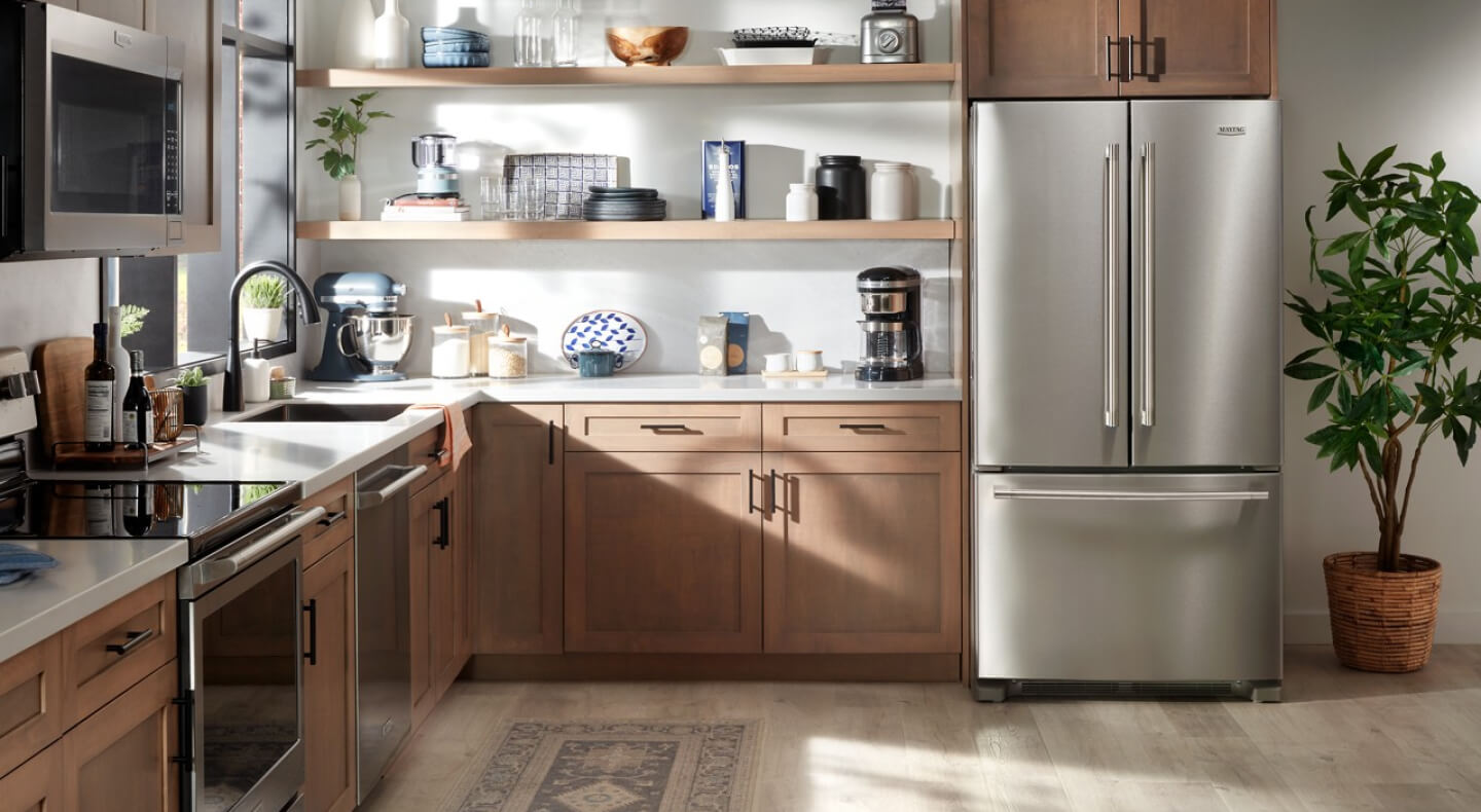 A light brown kitchen with stainless steel Maytag® appliances