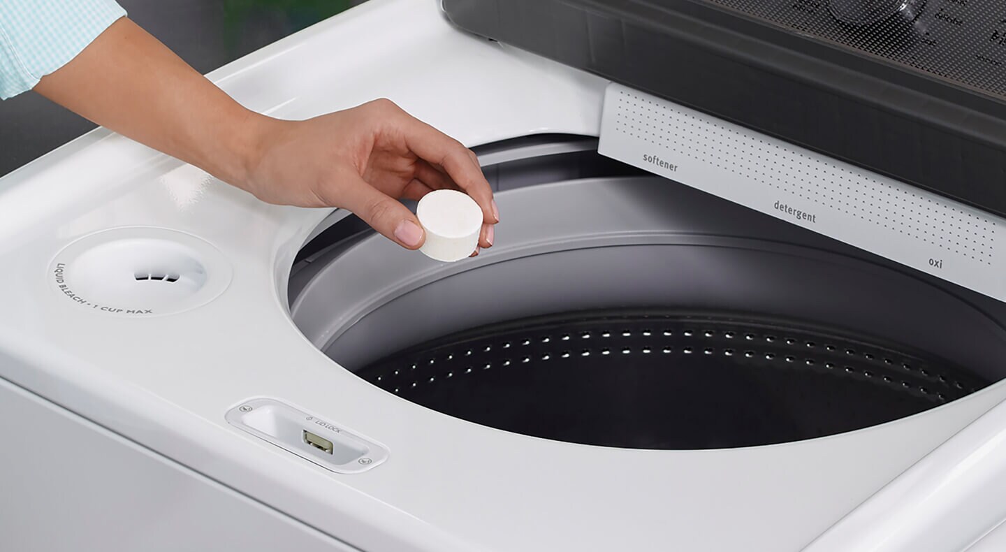 Person putting an affresh® tablet in a washing machine