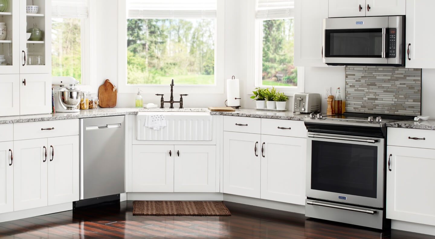 Stainless steel Maytag® electric range beneath over-the-range microwave