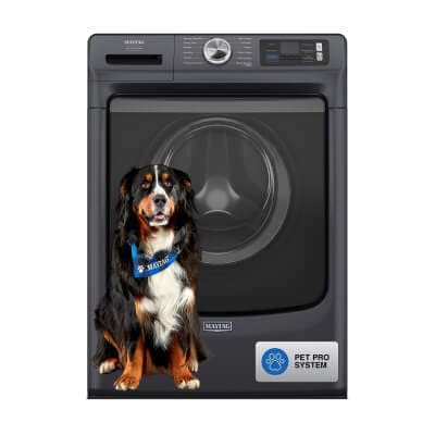 A large black, brown and white dog sitting in front of a Maytag® Smart Pet Pro Front Load Washer