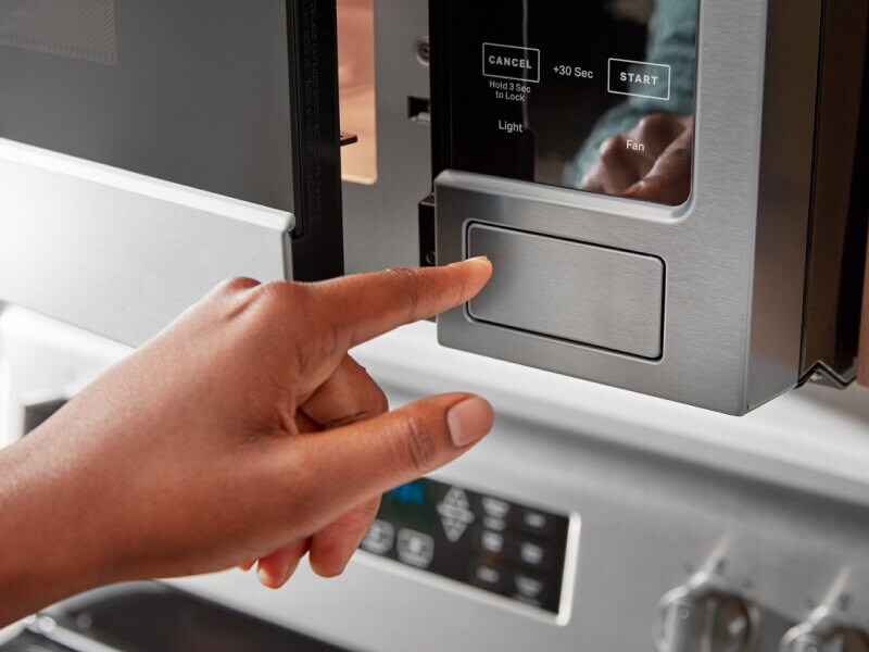 Hand opening a microwave