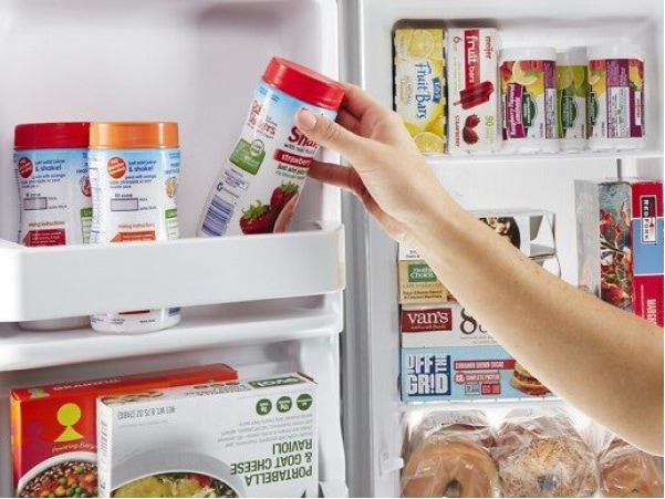 Person loading food into a refrigerator