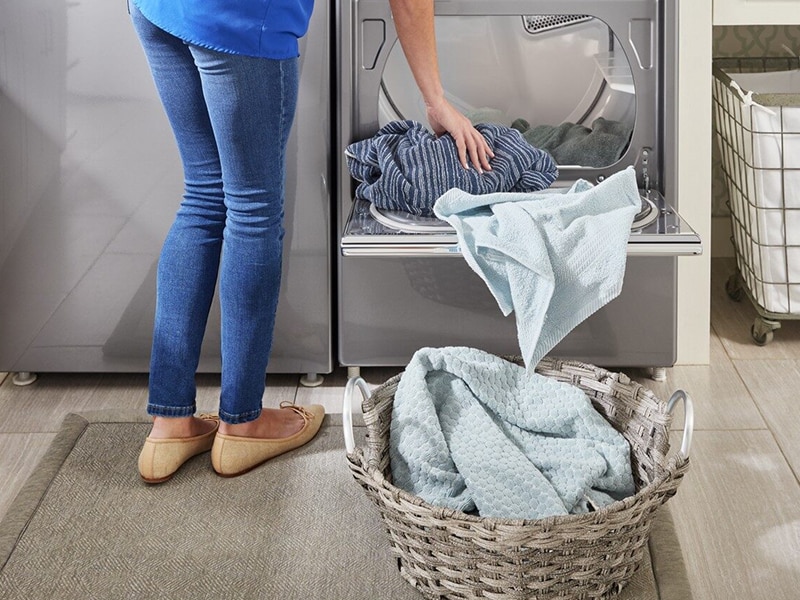 Person unloading clothes from an open dryer