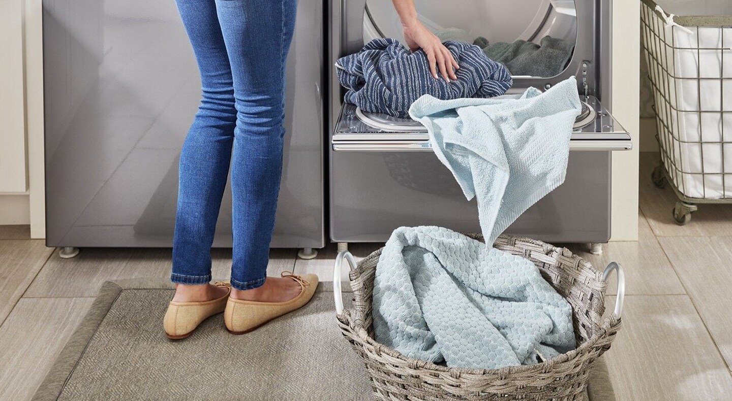 Person unloading clothes from an open dryer