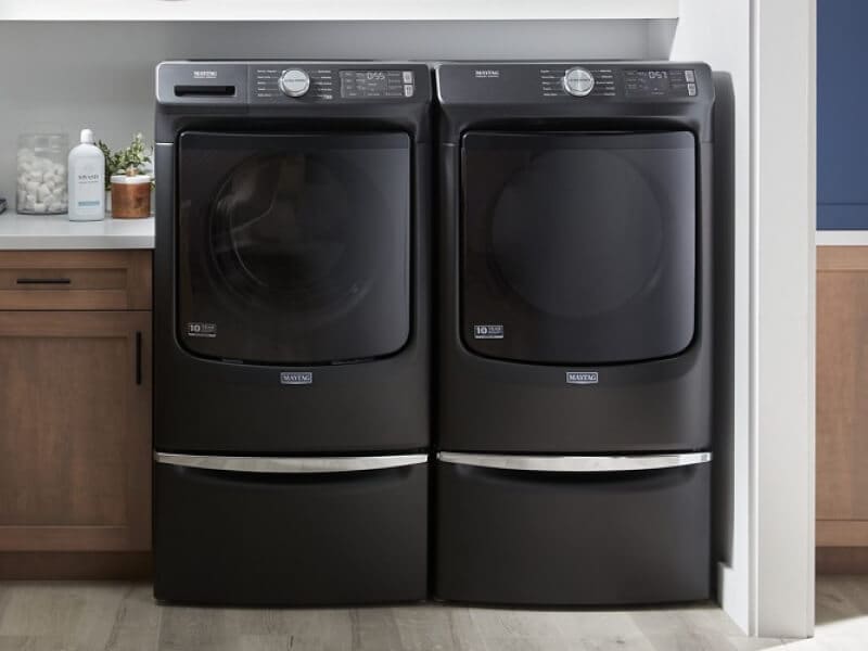 A Maytag® washer and dryer set in a laundry room with brown cabinetry A Maytag® washer and dryer set in a laundry room with brown cabinetry