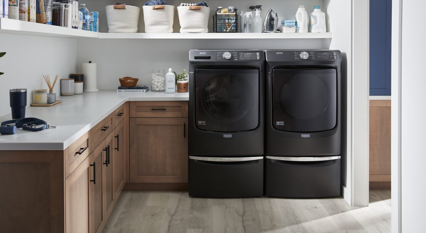 A Maytag® washer and dryer set in a laundry room with brown cabinetry A Maytag® washer and dryer set in a laundry room with brown cabinetry