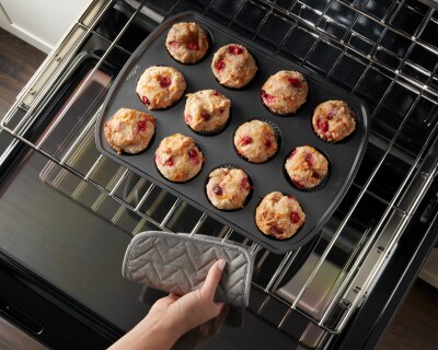 Person removing baked goods from an oven