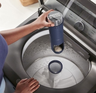 A person taking the Pet Pro Filter out of washing machine agitator