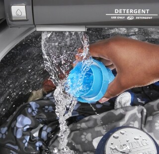 A person rinsing out a detergent cup