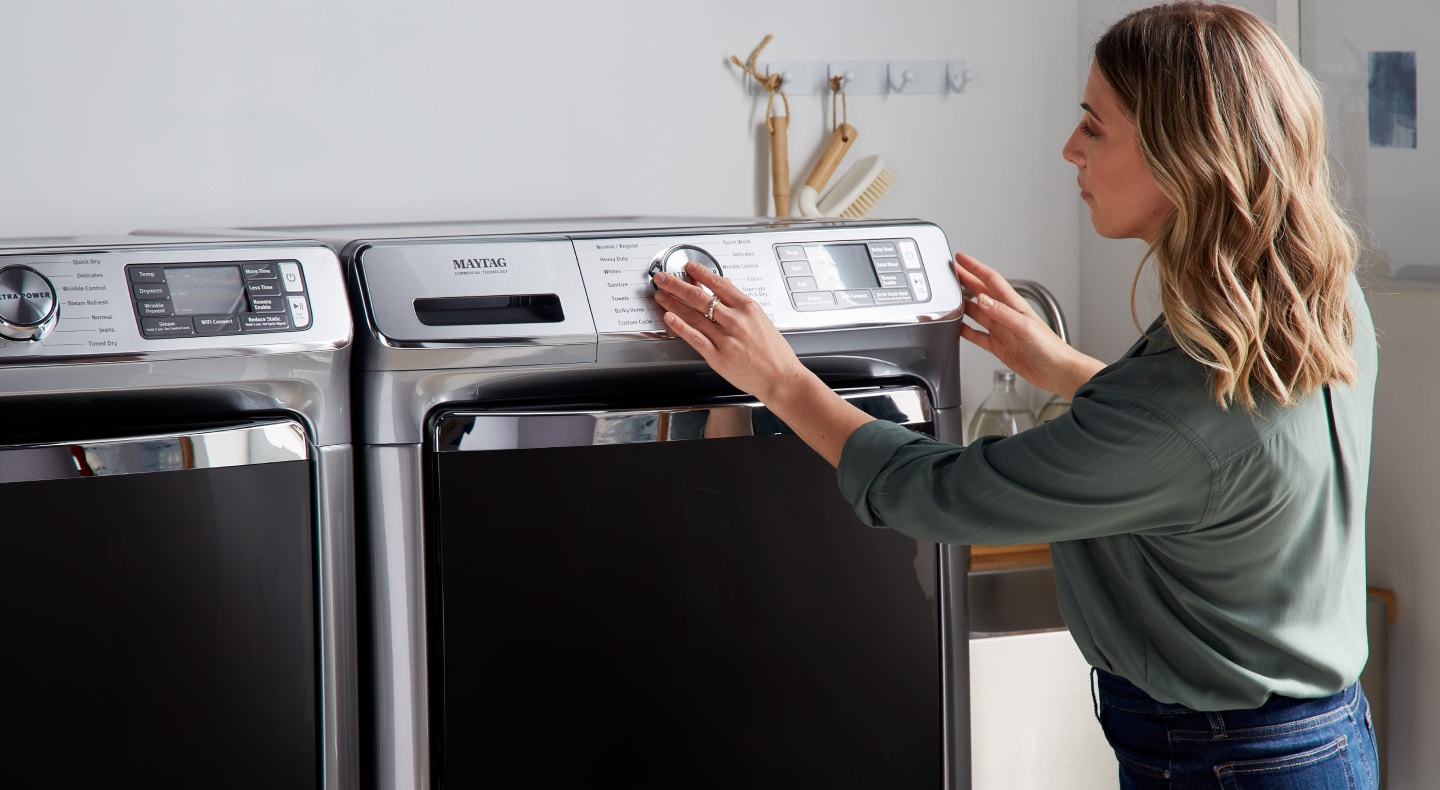 Person using a washing machine dial Person using a washing machine dial