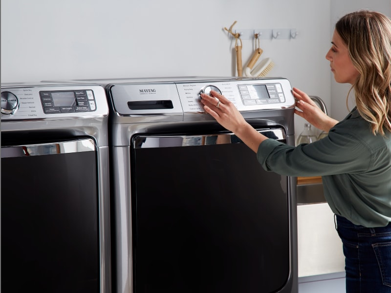 Person using a washing machine dial Person using a washing machine dial
