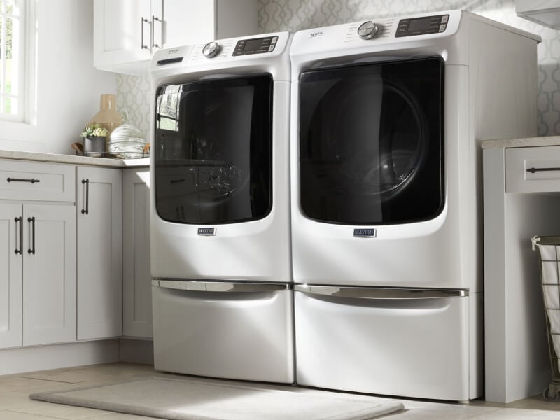 A Maytag® side-by-side top load washer and dryer in a modern laundry room A Maytag® side-by-side top load washer and dryer in a modern laundry room