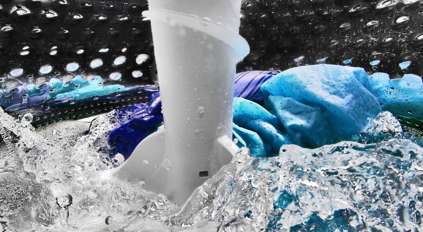 A closeup of laundry items spinning in water in a Maytag® washing machine drum A closeup of laundry items spinning in water in a Maytag® washing machine drum