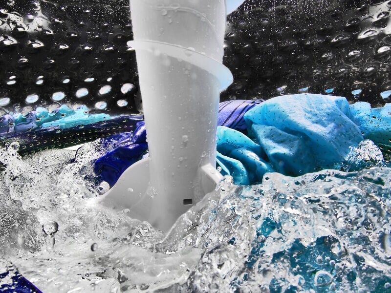 A closeup of laundry items spinning in water in a Maytag® washing machine drum A closeup of laundry items spinning in water in a Maytag® washing machine drum