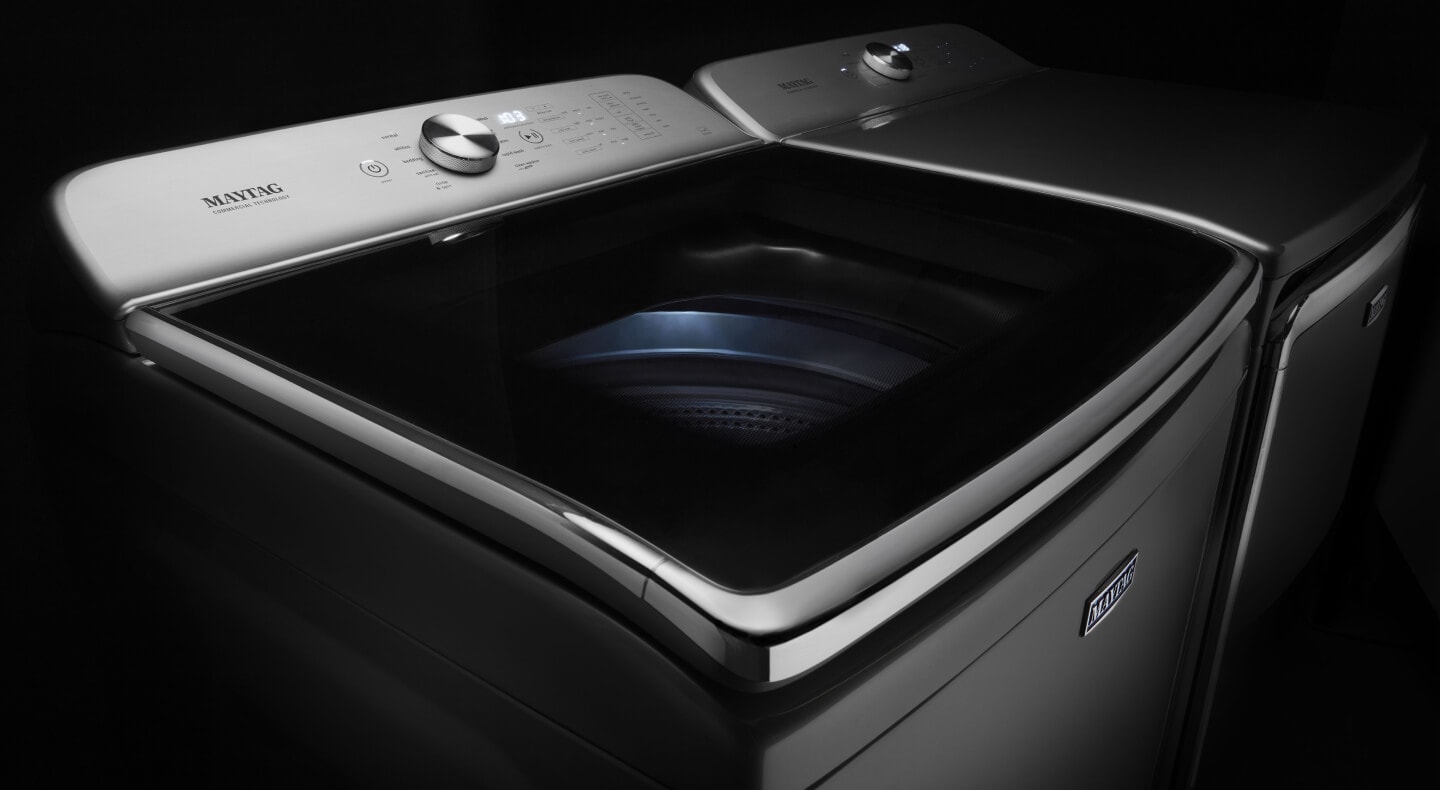 Maytag® stainless steel top load washing machine against a black background Maytag® stainless steel top load washing machine against a black background