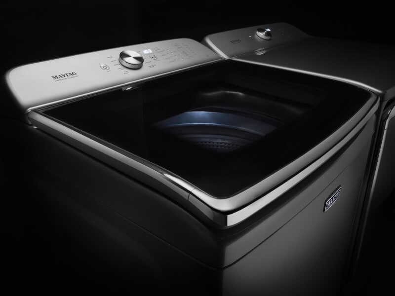Maytag® stainless steel top load washing machine against a black background Maytag® stainless steel top load washing machine against a black background