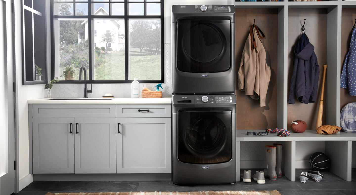Maytag® front load washer and dryer stacked in a laundry room