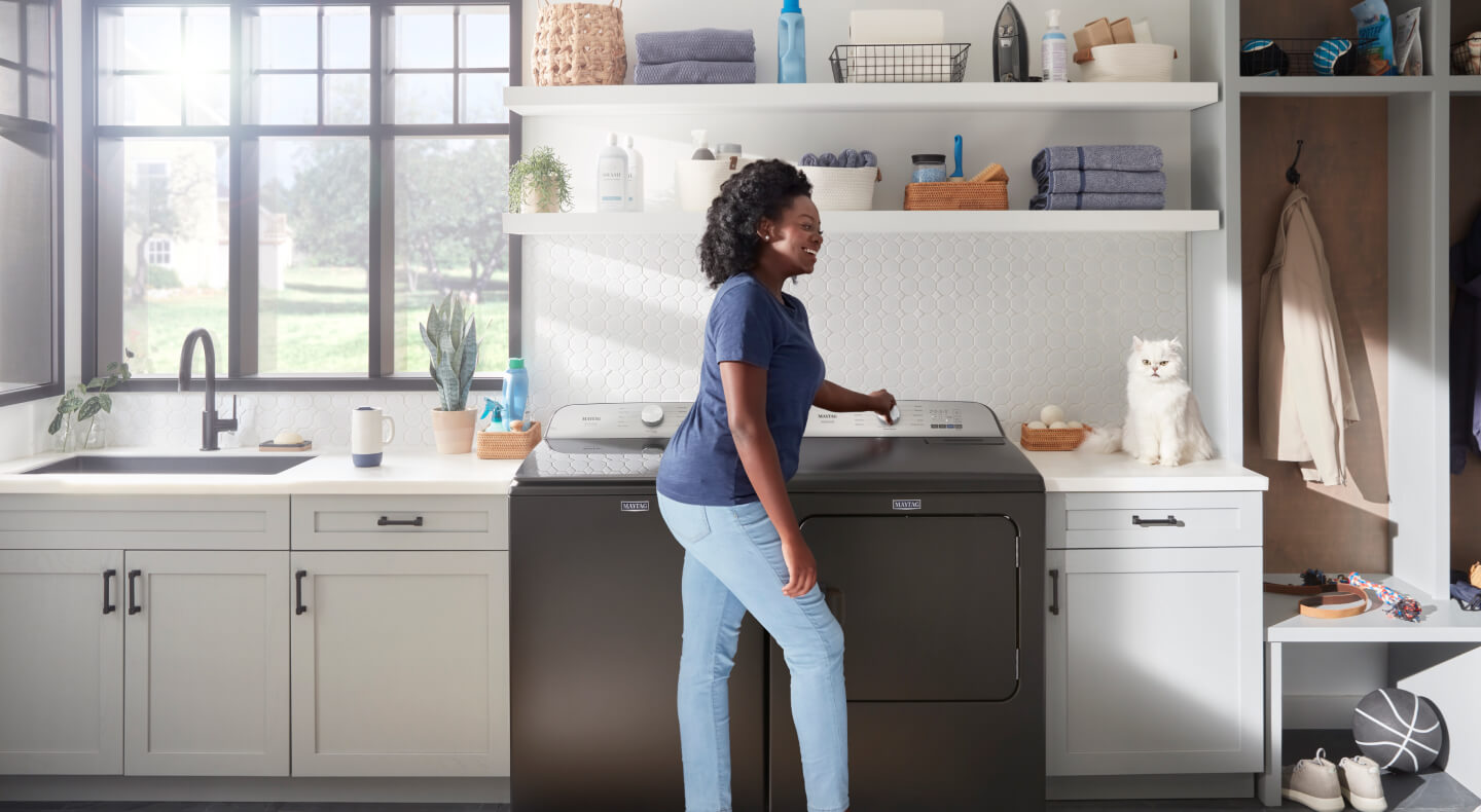 Person standing in front of a Maytag® top load laundry set