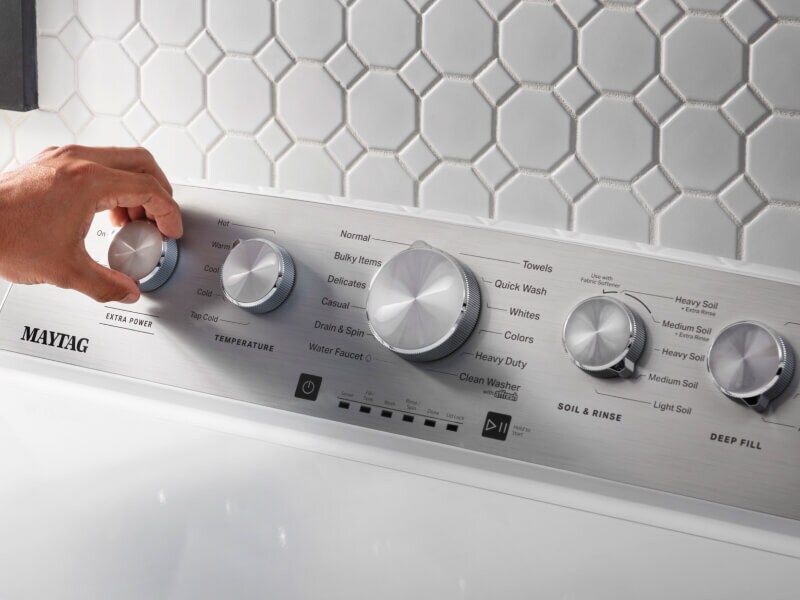 Person selecting a cycle setting on a Maytag® washing machine