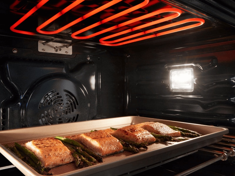 Fish and asparagus broiling in an oven