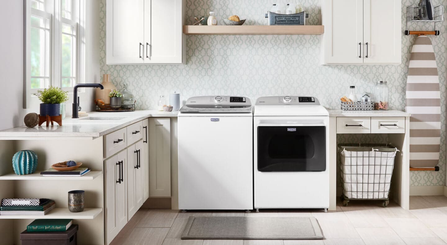 An organized laundry room featuring a Maytag brand washer and dryer
