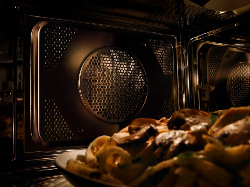 A close-up of a Maytag® convection microwave interior with a plate of pasta A close-up of a Maytag® convection microwave interior with a plate of pasta