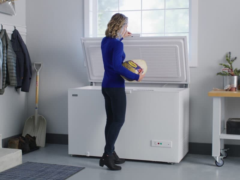 Person putting food in chest freezer 