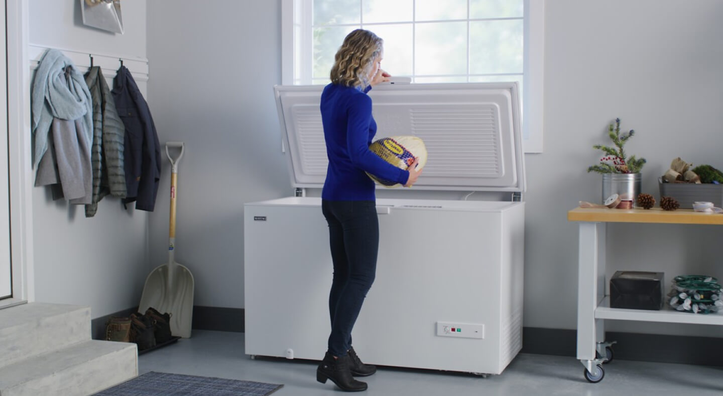 Person putting food in chest freezer 