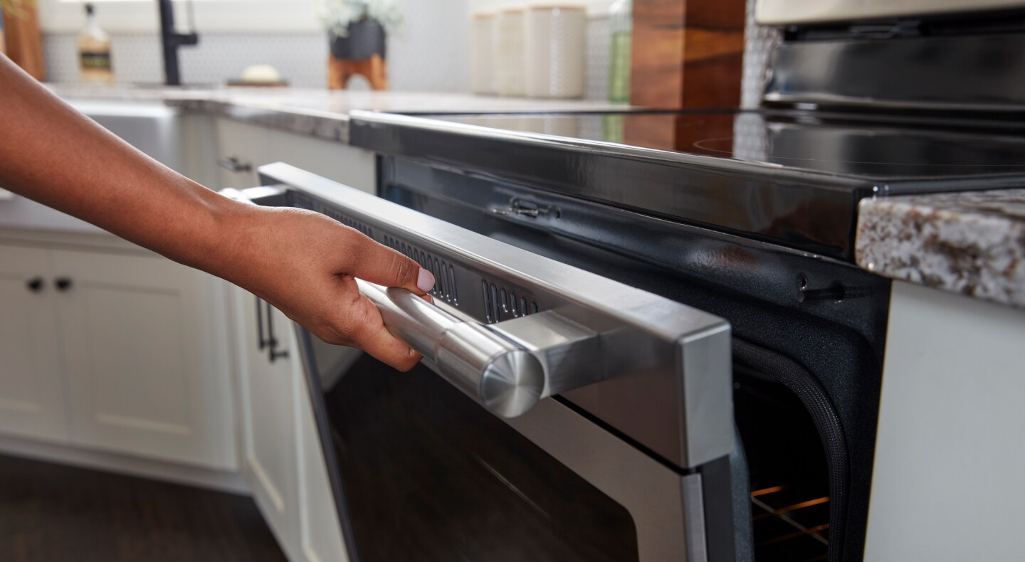 Person opening a Maytag® range oven door